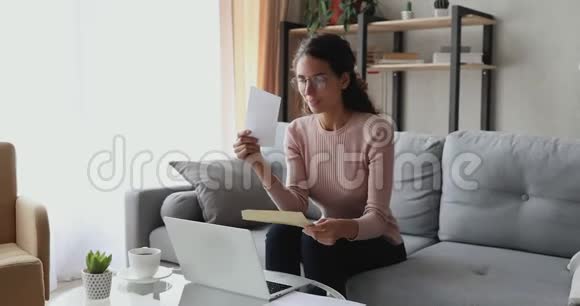 快乐兴奋的女人坐在沙发上看信视频的预览图