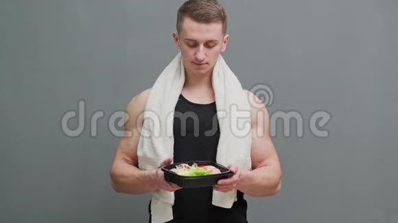 一个男人拿着一盒富含蛋白质的运动营养食品的特写镜头视频的预览图