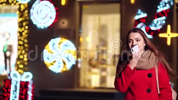 快乐的女孩在商店里散步晚上打电话视频的预览图