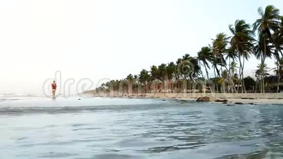 清晨年轻的西班牙裔女孩沿着海滩奔跑视频的预览图