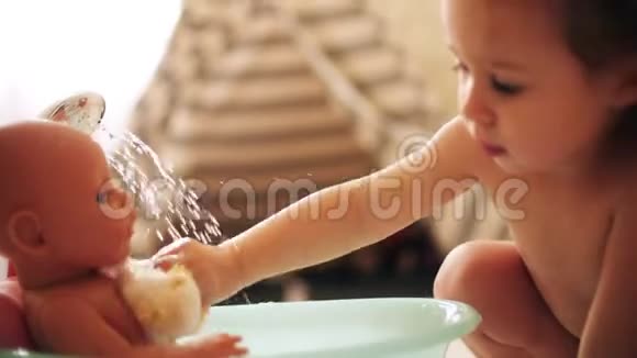 小女孩在玩具浴盆里洗娃娃视频的预览图
