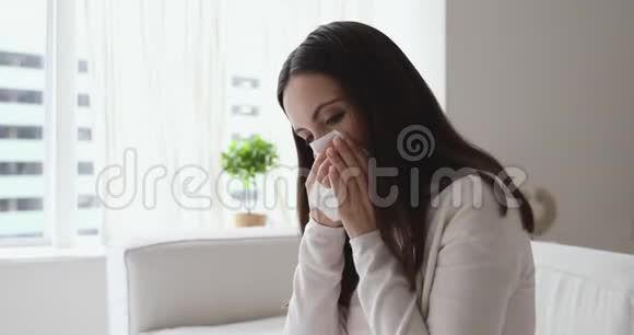 患有过敏性鼻炎的不健康青年妇女在家吹鼻视频的预览图