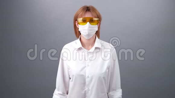 病毒防护特写一个戴着医疗帽的医生女人的脸戴上口罩和防护眼镜2019视频的预览图