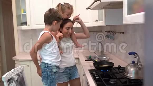 微笑的母亲和孩子们在厨房做饭跳舞视频的预览图