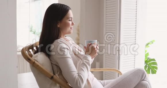 喝热茶呼吸新鲜空气的女性视频的预览图