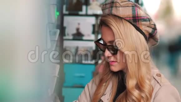 一个年轻的巴黎人在街头商店里选择一张明信片戴着贝雷帽和太阳镜的漂亮女孩买了一张卡片来纪念视频的预览图