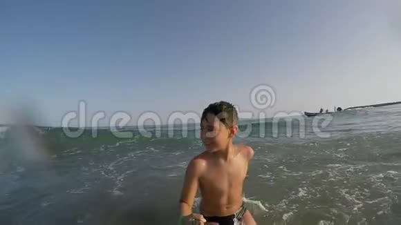 男孩向后跑掉进海浪里视频的预览图