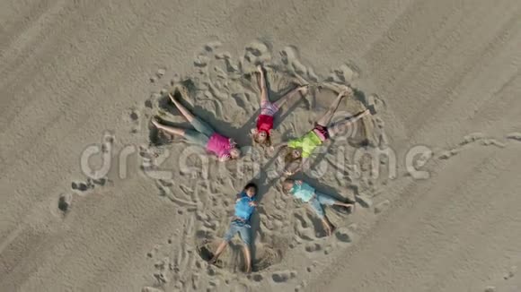 五个孩子躺在沙子上像星星一样挥舞着手视频的预览图