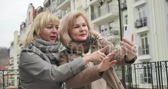 快乐的白种人高级女性在户外摆出自拍照片积极无忧无虑的退休人员在户外自由活动视频的预览图