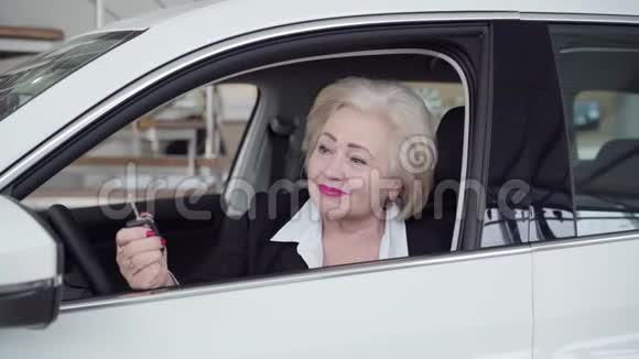 快乐的高加索族女人拿着车钥匙看着相机微笑的肖像成功的金发女商人视频的预览图