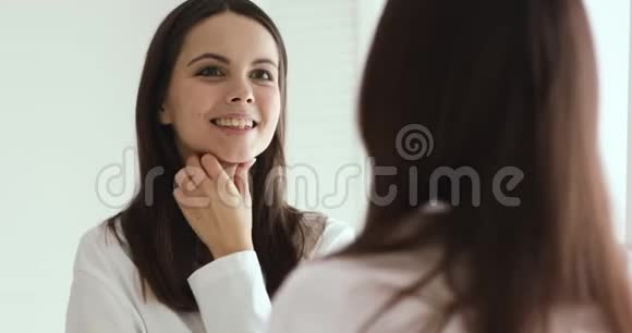 快乐自信的女孩享受健康的面部皮肤照镜子视频的预览图