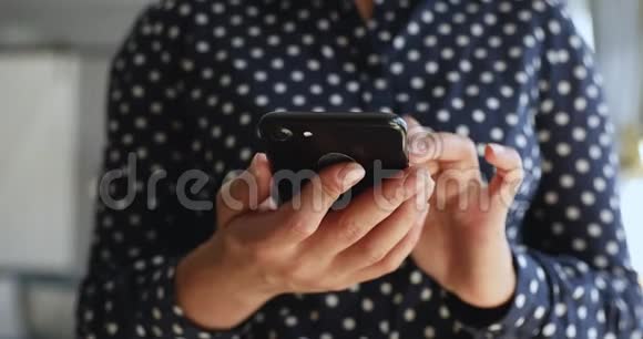 关闭年轻女性持有智能手机使用移动应用程序视频的预览图