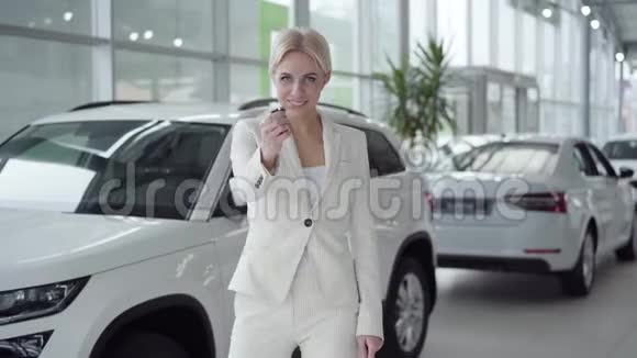 年轻自信的女士带着车钥匙转向相机微笑着成功的白人女性视频的预览图