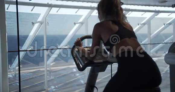 健身房里的女人骑着运动自行车视频的预览图