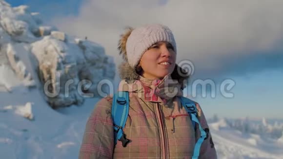 在阳光明媚的冬日幸福的女人在山顶欣赏大自然视频的预览图