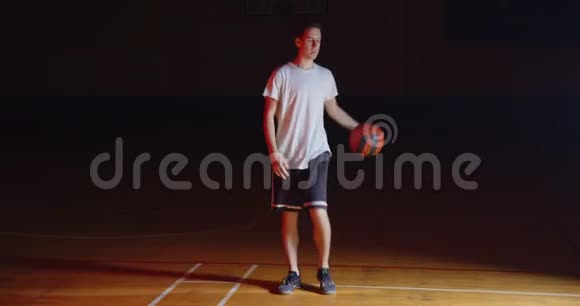 白种人篮球运动员运球专业黑暗相机光线视频的预览图