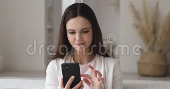 兴奋的女孩拿着智能手机在社交媒体上阅读好消息视频的预览图
