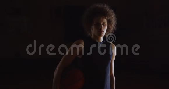 流行的卷发白人篮球运动员画像严肃地看摄影记者闪光灯持球视频的预览图