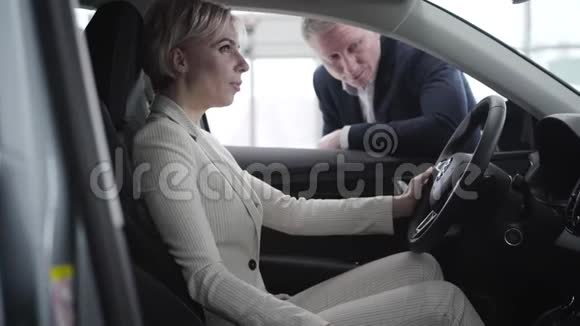 美丽优雅的高加索女人坐在车里和经销商交谈的肖像丰富的侧观视频的预览图