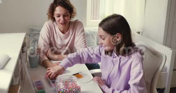 妈妈和十几岁的女儿在家做创造性的休闲活动视频的预览图