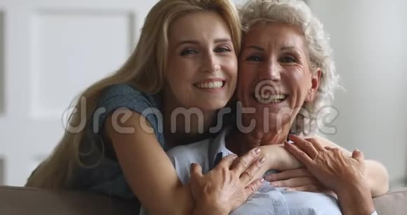 迷人的年轻女子拥抱微笑的老年母亲视频的预览图