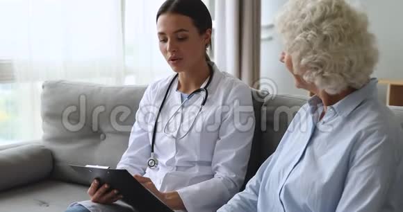 年轻的专业全科医生在体检期间以卡片形式书写视频的预览图