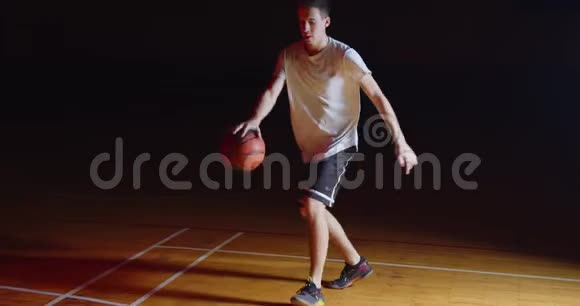 白种人篮球运动员运球专业黑暗相机光线视频的预览图
