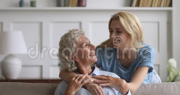 微笑着年轻可爱的女人拥抱从年长成熟的妈妈视频的预览图
