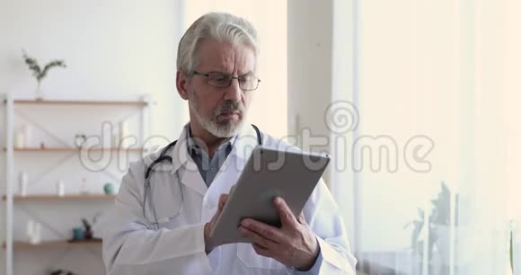 工作中使用数码平板电脑的成年男性医生视频的预览图