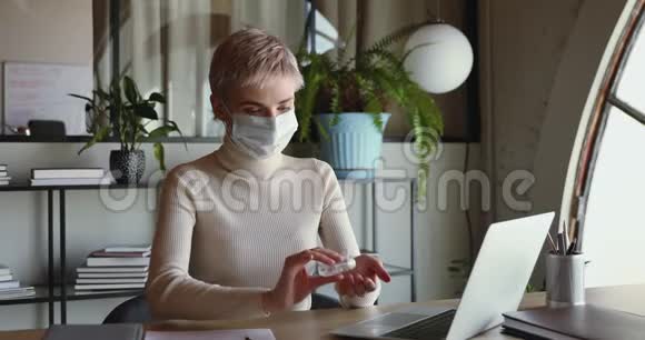 女办公室工作人员戴口罩用消毒凝胶清洁双手视频的预览图