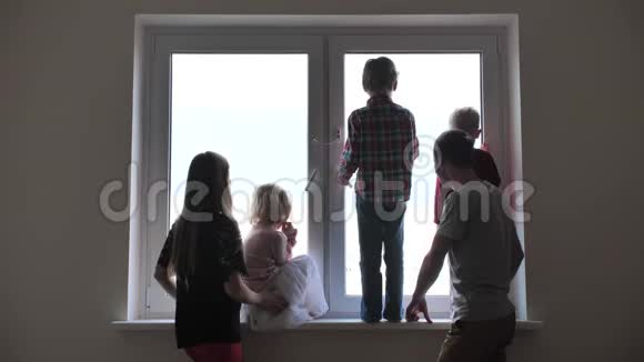 一个大家庭的剪影背景是一个新公寓的窗户视频的预览图