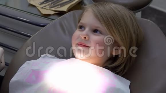 当牙医检查她的牙齿时女孩正坐在一张特殊的椅子上视频的预览图