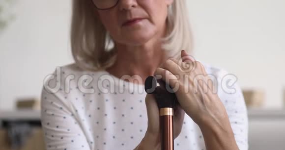 不高兴的压力老妇人用手扶着手杖视频的预览图