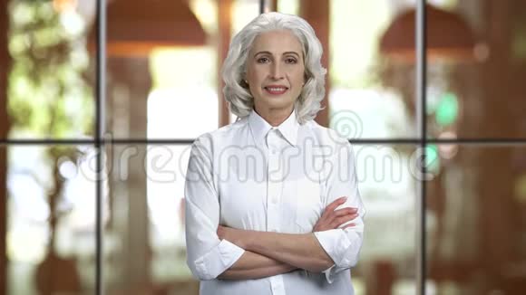 一位白发苍苍的女士穿着白色衬衫双臂交叉视频的预览图
