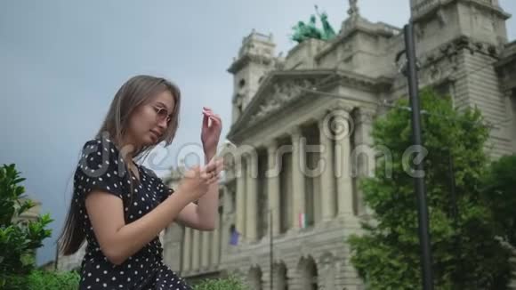 使用智能手机的年轻妇女布达佩斯民族博物馆背景视频的预览图