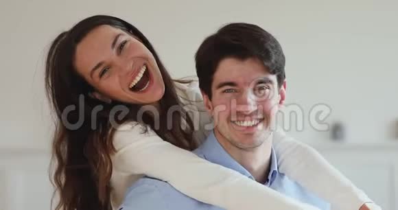 年轻夫妇带着牙齿笑着一起看镜头视频的预览图
