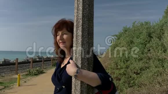 在阳光明媚的夏日女人幸福美丽在海洋海岸戴着手镯耳环旅行假期退休视频的预览图