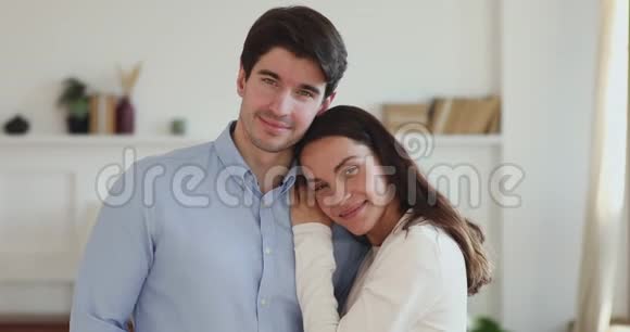美丽幸福的年轻夫妇在公寓里看着摄像机视频的预览图