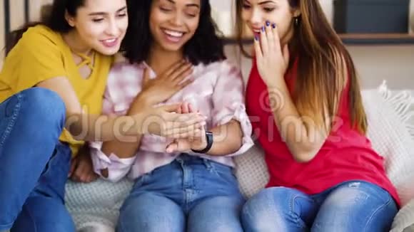 快乐的黑人女孩在家里给多种族的女性朋友展示订婚戒指视频的预览图