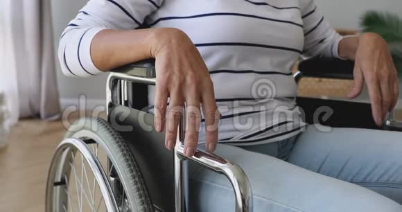 退休的老年妇女独自坐在轮椅上在家里视频的预览图