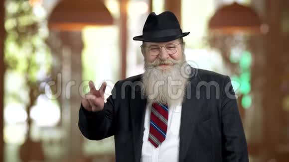 穿西装的老胡子男子展示了胜利的姿态视频的预览图