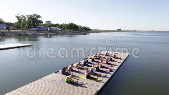 早上一群人在湖边的码头上做瑜伽视频的预览图