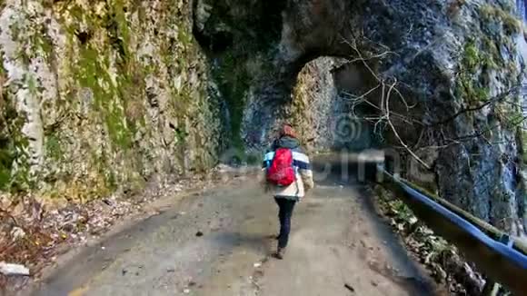 一位年轻的女摄影师背着背包在美丽的山上旅行视频的预览图