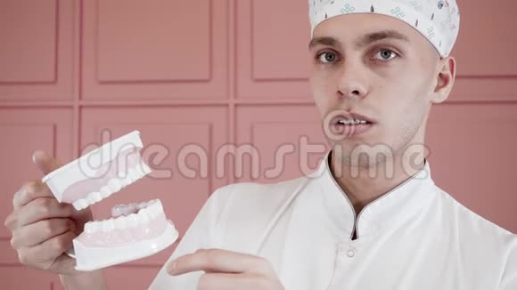 一个年轻人带着牙套笑着拍下颚植入物的肖像视频的预览图