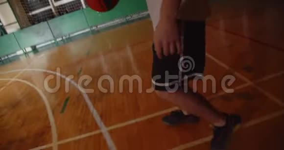 年轻的白种人篮球运动员把球扔进篮筐夜晚黑暗的轮廓后视运球视频的预览图