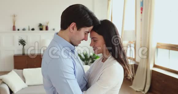 幸福浪漫的情侣在一起拥抱在家看着相机视频的预览图