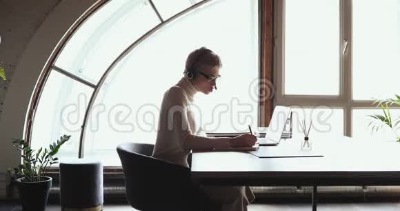 千禧一代女商人一个人坐在办公室里打电话的视频视频的预览图