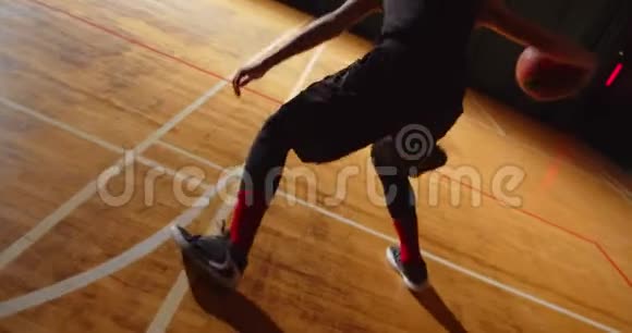 年轻的卷曲职业篮球运动员把球扔进篮筐夜晚黑暗的轮廓后视视频的预览图