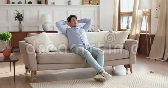 微笑的男人在舒适的客厅里放松视频的预览图