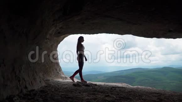 女旅行者穿过洞穴洞穴城附近的巴赫奇萨莱托普凯门克里米亚的景点慢动作视频的预览图